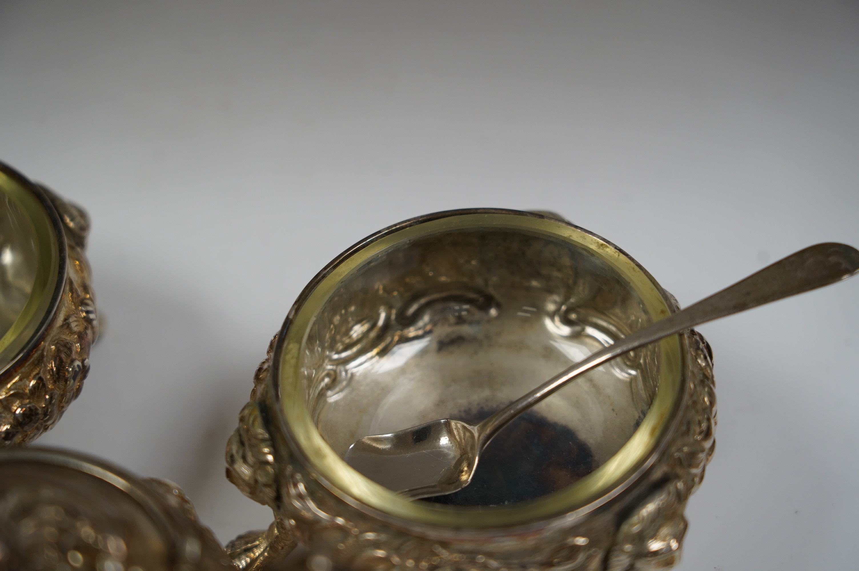 A Georgian Scottish silver mustard pot, width 9cm, marks rubbed, and a pair of similar Irish? silver cauldron salts and two associated later spoons. Condition - poor to fair